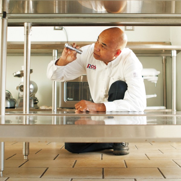 A Man is Inspecting the Kitchen  for Pest Service in Chicago, IL